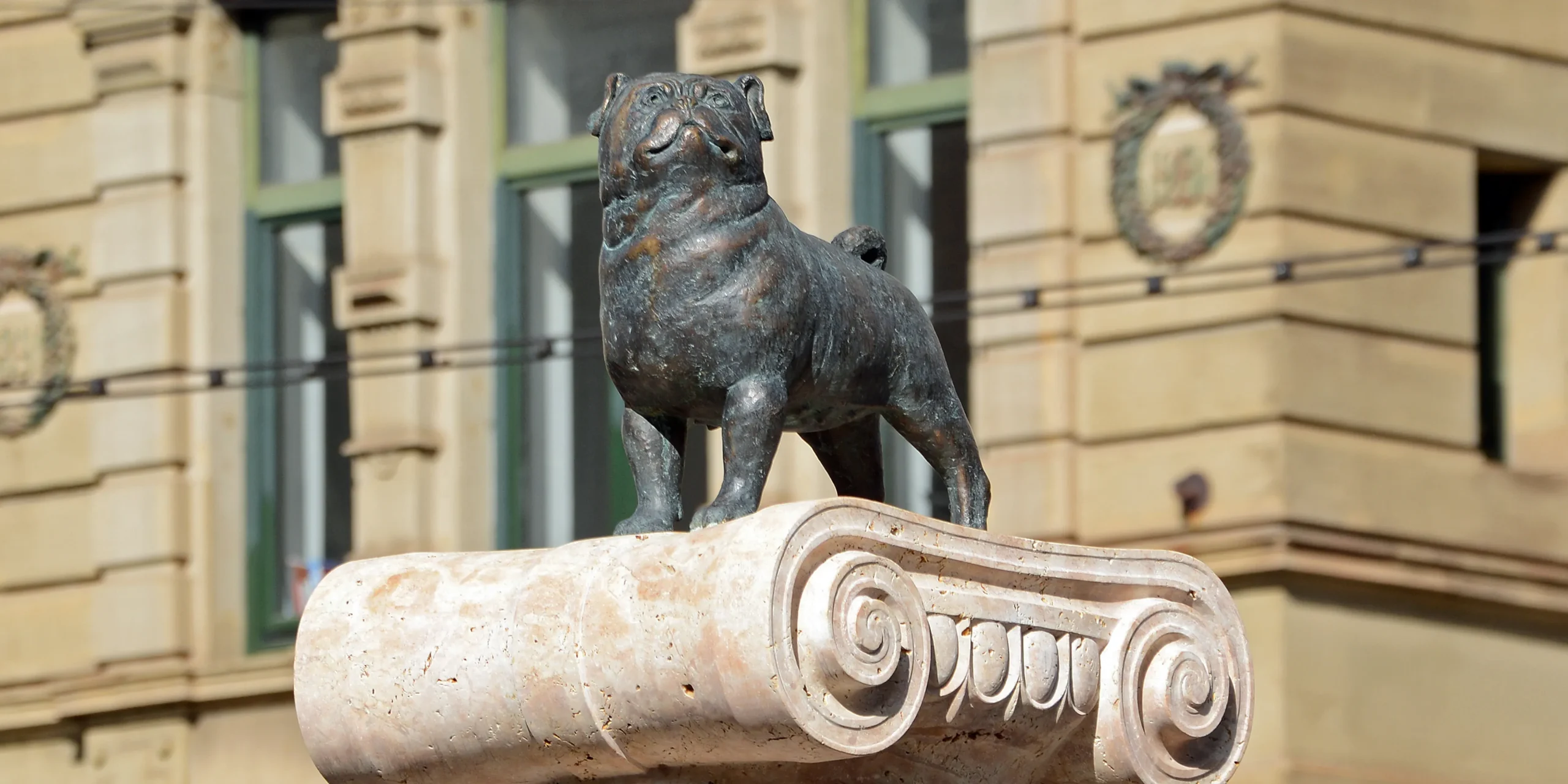 Bronzeskulptur des Waldmops auf einem Säulenkapitell in Brandenburg an der Havel