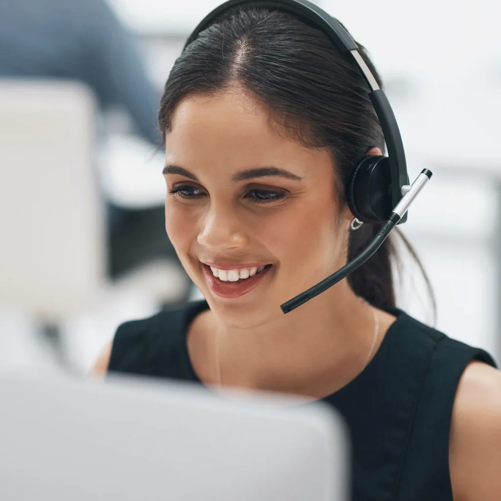Mitarbeiterin mit Headset im Kundendialog